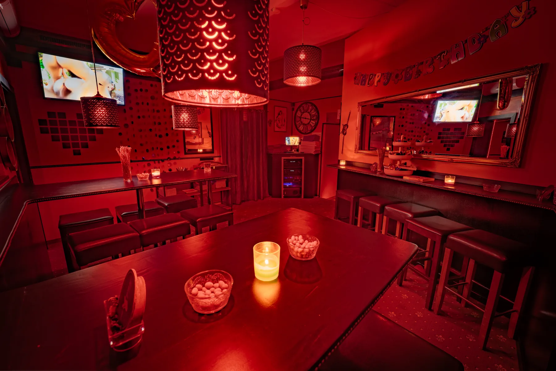 Lounge-Sitzecke mit Tanzstange und Blick zur Bar
